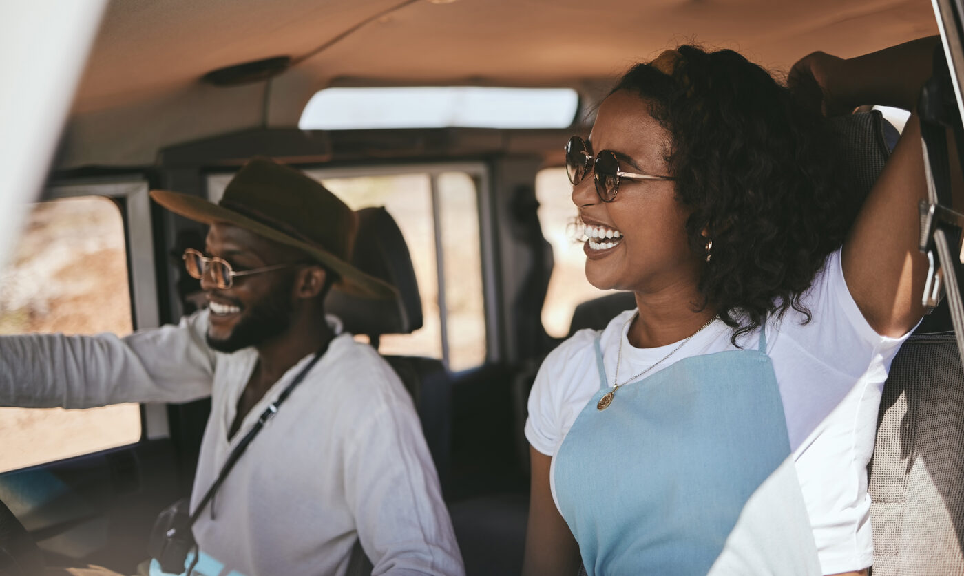 Friends laughing together on a road trip in a rented car