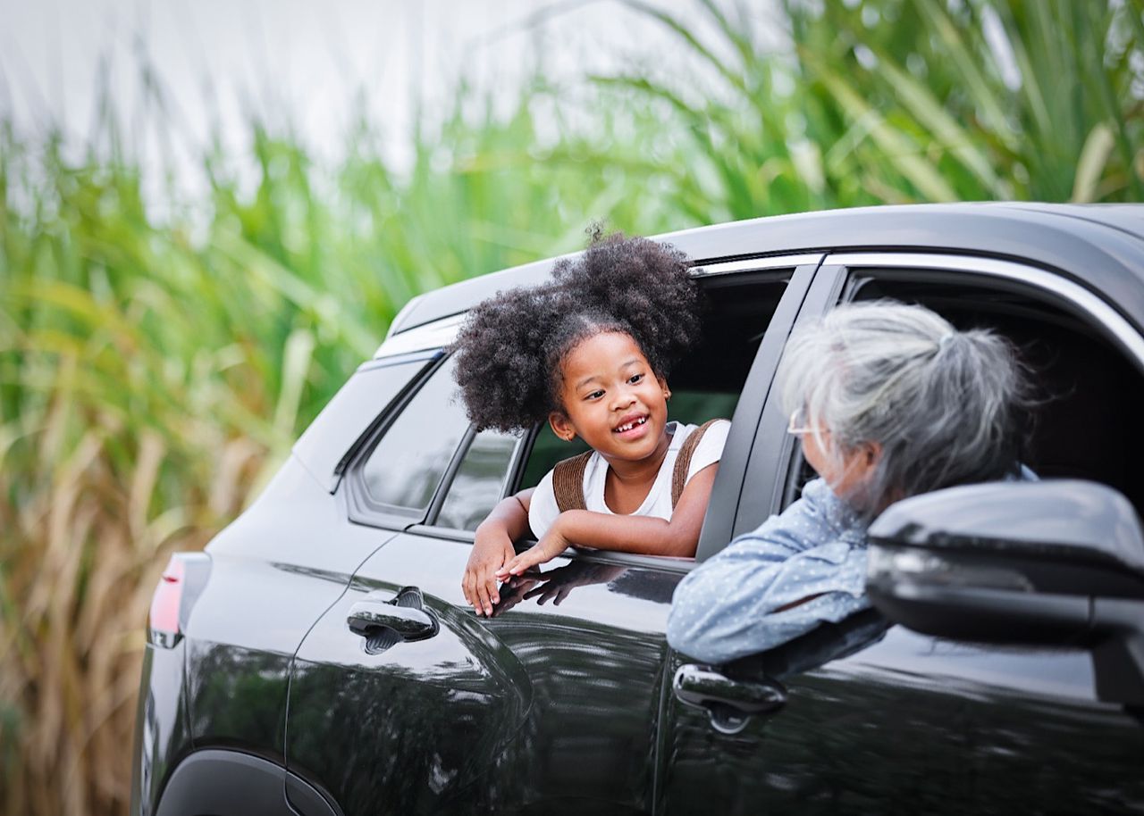 Curly hair girl in car talking with her grandmother by thanyapatm