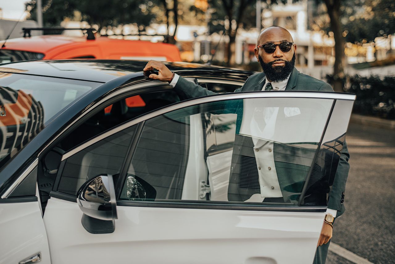 African executive beside a white car by SkyNextphoto