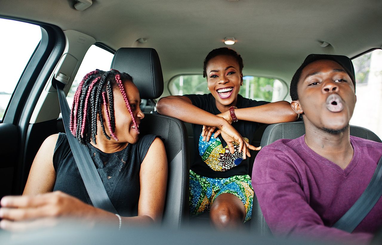 Excited Friends Enjoying Road Trip Together in Car by ASphotostudio